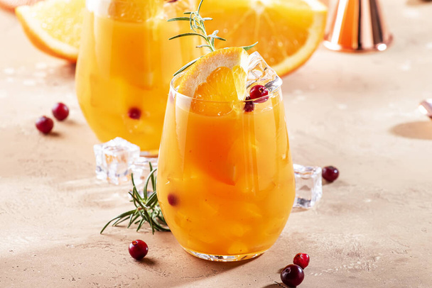 Fresh cocktail with orange, cranberry, rosemary and ice. Alcoholic, non-alcoholic drink beverage with bar tools, copy space - Photo, image