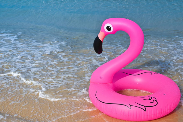 forme de flamant rose, anneau en caoutchouc flottant près de la plage
 - Photo, image
