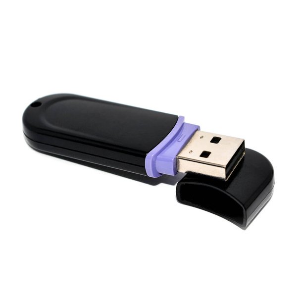 Plastik USB flaş bellek beyaz arka planda bir kapağın üzerinde duruyor - Fotoğraf, Görsel