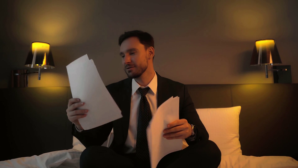 šťastný podnikatel házení do vzduchu dokumenty v hotelovém pokoji  - Záběry, video