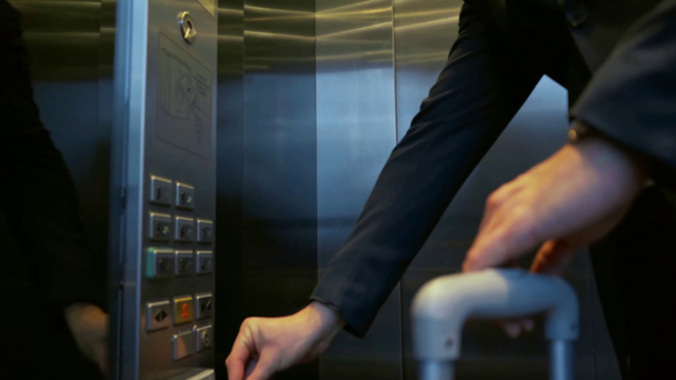 rack focus of businessman pressing buttons in elevator  - Filmati, video