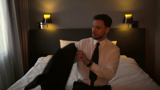 handsome businessman touching tie and wearing blazer  - Footage, Video