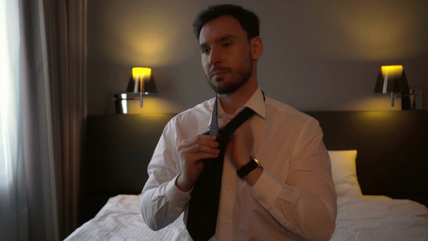 ホテルの部屋でネクタイをしてるハンサムなビジネスマン  - 映像、動画
