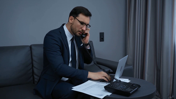 ノートパソコンを使いレトロな電話で話すビジネスマンは  - 映像、動画