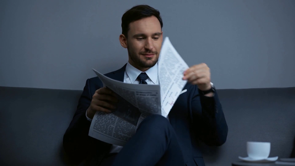 gelukkige zakenman leest krant in de buurt van beker in hotel - Video