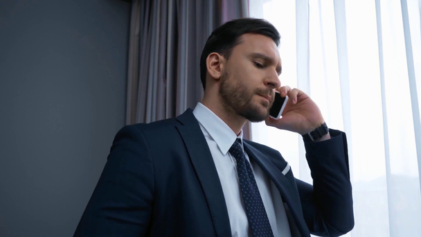 χαρούμενος επιχειρηματίας με κοστούμι μιλάει στο smartphone  - Πλάνα, βίντεο