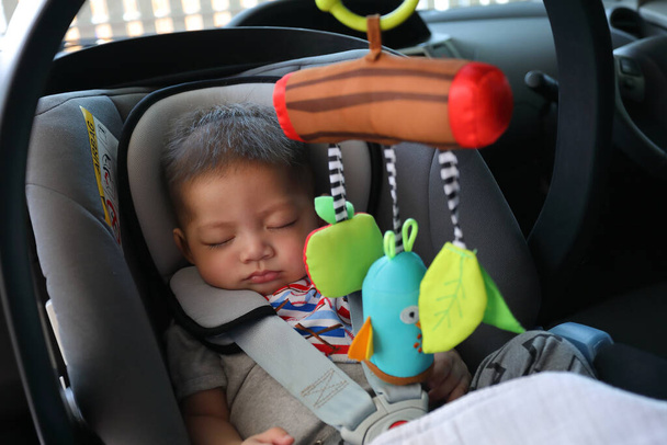 lindo bebé niño durmiendo en asiento de coche cinturón de seguridad de bloqueo de protección conducir viaje por carretera
 - Foto, imagen
