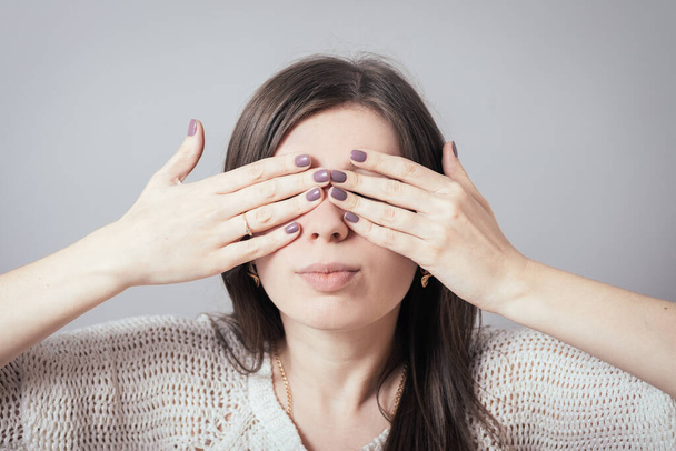 girl closes eyes with her hands - Φωτογραφία, εικόνα