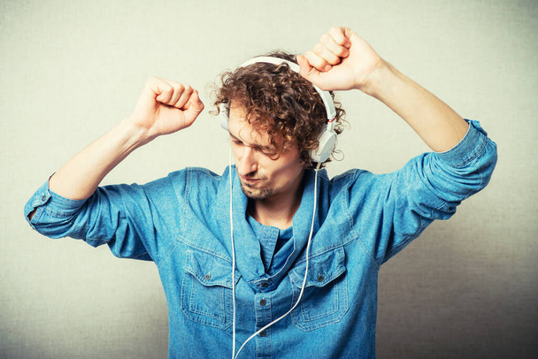 curly man listening to music on headphones white, dancing - Fotoğraf, Görsel