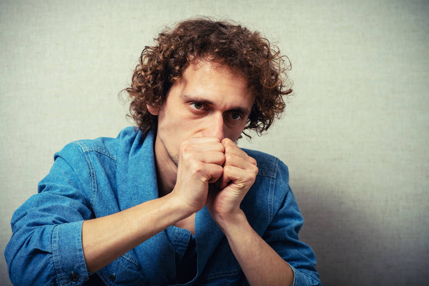 curly-haired man praying, clasped his hands together - Photo, Image