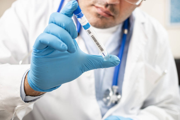 Vista do médico caucasiano com tubo de ensaio fictício sobre fundo branco
. - Foto, Imagem