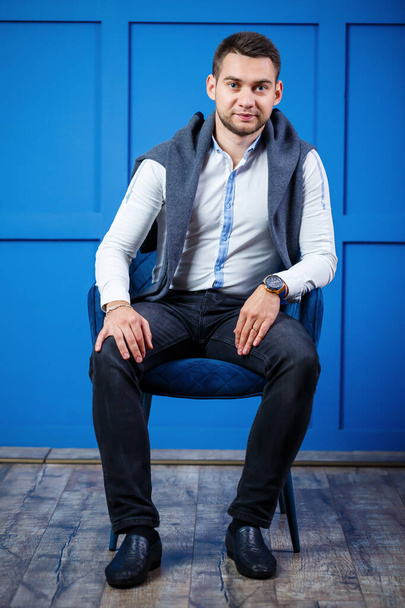 young businessman in a white shirt on a blue background - Valokuva, kuva