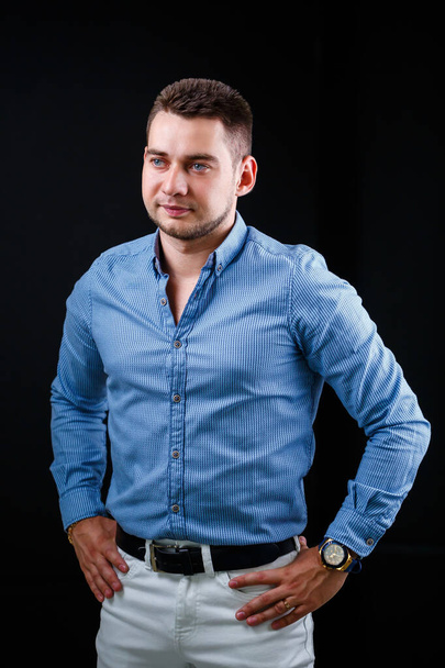 Συνάδελφος επιχειρηματίας με μπλε πουκάμισο και λευκό παντελόνι σε μαύρο φόντο - Φωτογραφία, εικόνα