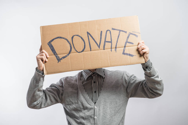 young man showing board with text: Donate - Photo, Image