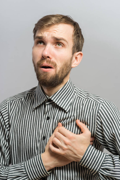 A young man suffering from heart pain - Fotoğraf, Görsel
