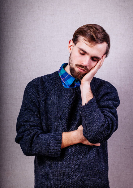 young man with beard in blue sweater dozing - Φωτογραφία, εικόνα
