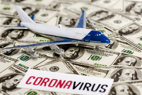 selektiver Fokus des Coronavirus-Karten- und Flugzeugmodells auf Dollar-Banknoten, Konzept zur Wirtschaftskrise - Foto, Bild