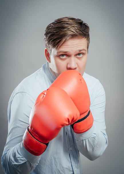 Portrait of young man in red boxing gloves fighting - Foto, Bild