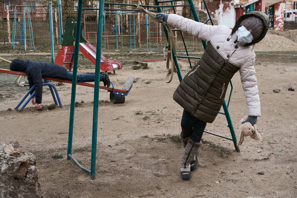 концепция эпидемии и карантина - Гриль и мальчик в маске на детской площадке в городе
 - Фото, изображение
