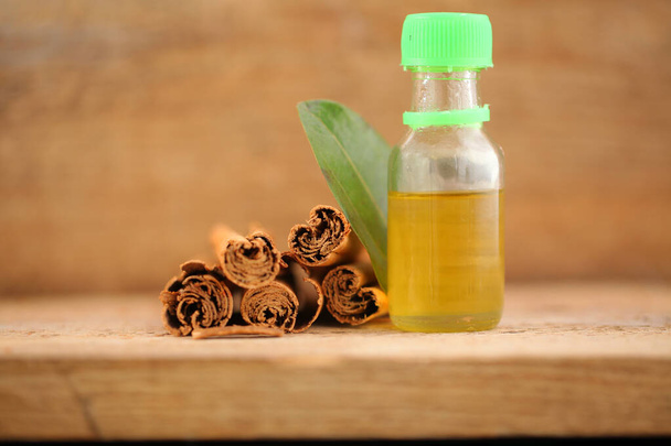 hoja de canela y corteza de árbol. aceite esencial de canela en una botella
 - Foto, Imagen