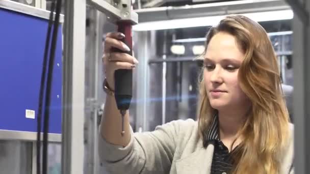 Ο χειριστής μηχανών βιδώνει το συστατικό στη γραμμή συναρμολόγησης από το κατσαβίδι - Πλάνα, βίντεο
