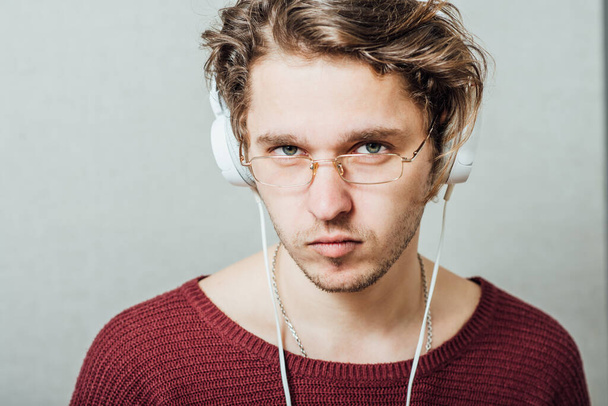 Man in headphones listening to music. On a gray background. - Foto, Imagem