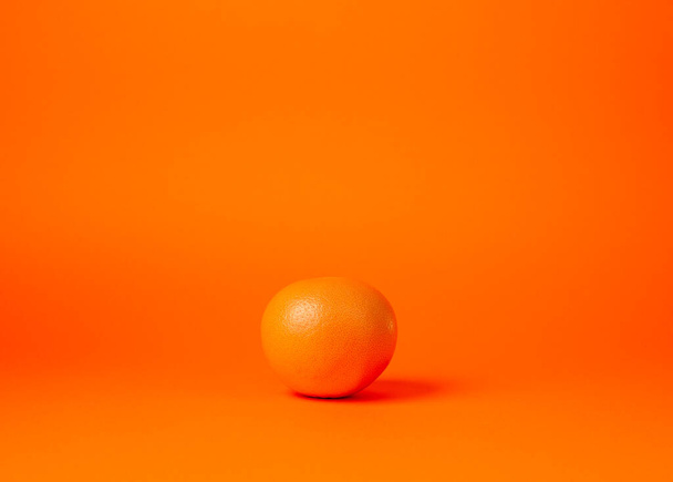 whole grapefruit on an orange background - 写真・画像