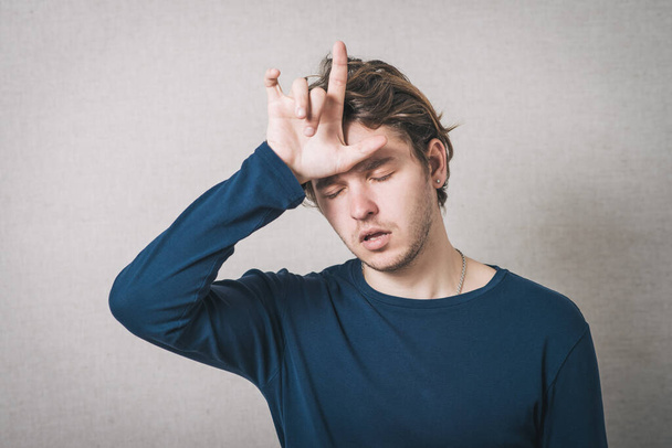 Mann Kopfschmerzen, Hand auf dem Kopf. Grauer Hintergrund - Foto, Bild