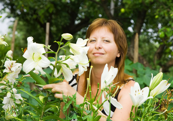 Mujer con lirio en el jardín
 - Foto, imagen