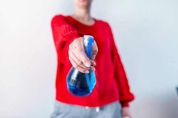 Mujer manos con alcohol desinfectante prevenir el virus y bacterias, concepto de higiene. Mujer desinfectando mesa rociando un desinfectante azul de una botella.Prevenir covid19, virus de la corona
. - Foto, Imagen