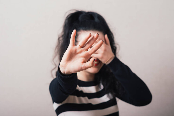 Woman showing a stop hand and closes her eyes. Gray background. - 写真・画像