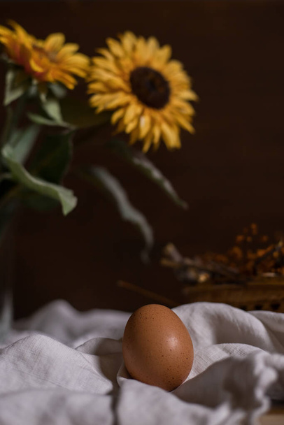 яйце з гніздом і квітка сонця на дерев'яному фоні
 - Фото, зображення
