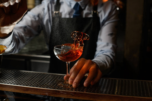 glass with splashing drink on bar counter - 写真・画像