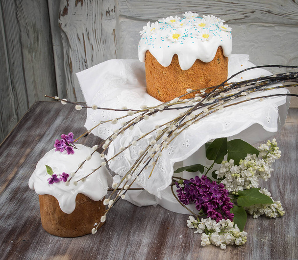Easter cake kulich. Traditional Easter sweet bread decorated meringue and  candy cane shape eggs on plate on wooden table background - Foto, afbeelding
