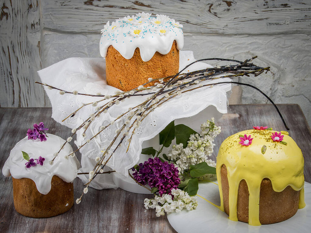 Easter cake kulich. Traditional Easter sweet bread decorated meringue and  candy cane shape eggs on plate on wooden table background - Foto, immagini