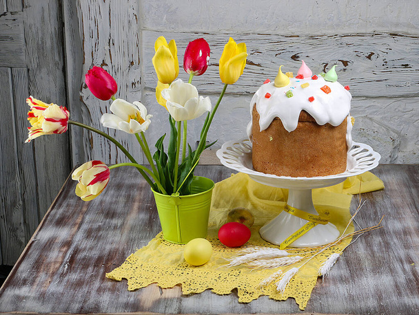 Easter cake kulich. Traditional Easter sweet bread decorated meringue and  candy cane shape eggs on plate on wooden table background - Foto, Imagen