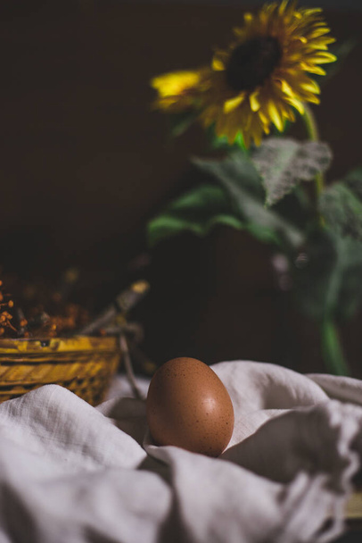 яйце з гніздом і квітка сонця на дерев'яному фоні
 - Фото, зображення
