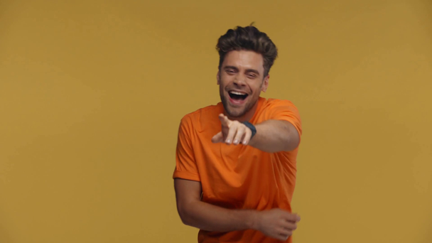 Hombre riendo al señalar con el dedo a la cámara aislado en amarillo
 - Metraje, vídeo