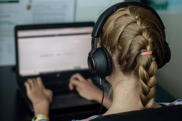 Concepto de Coronavirus. Chica adolescente sentada con su computadora portátil - aprendizaje en línea desde casa
 - Foto, imagen