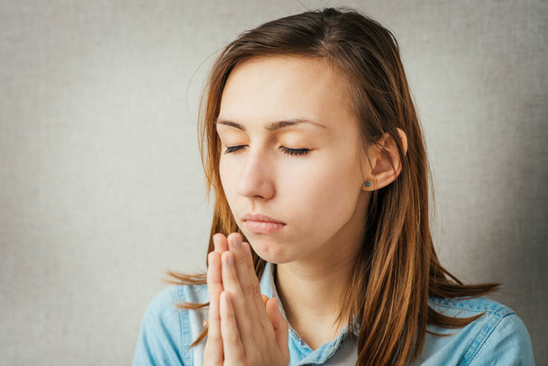 girl praying with his eyes closed - Photo, image