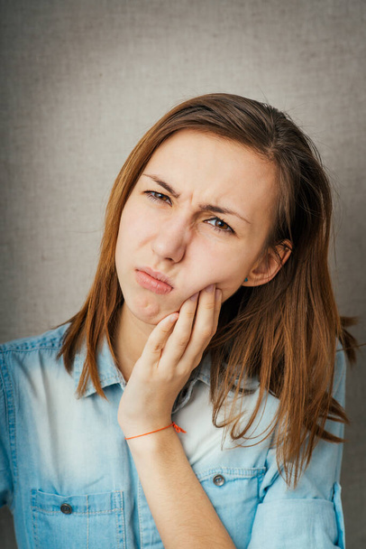 girl toothache in photo studio background - Foto, afbeelding