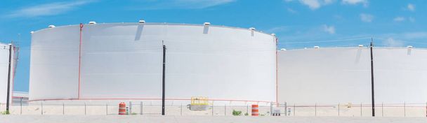 Панорамний вид ряду білих нафтових резервуарів під хмарним блакитним небом в Корпус-Крісті, штат Техас, США. Великий промисловий контейнер для бензину, нафти, природного газу. Танкова ферма на нафтопереробному заводі. - Фото, зображення
