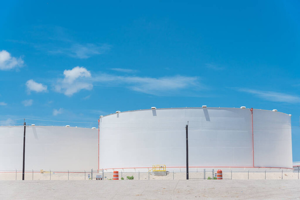 Ряд білих нафтових резервуарів під хмарним блакитним небом в Корпус-Крісті, штат Техас, Америка. Великий промисловий контейнер для бензину, нафти, природного газу. Танкова ферма на нафтопереробному заводі. - Фото, зображення