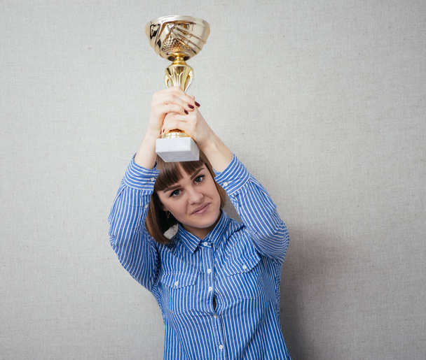 Half-length portrait of business woman keeping gold cup, isolated on white. Concept of victory and success - Photo, image