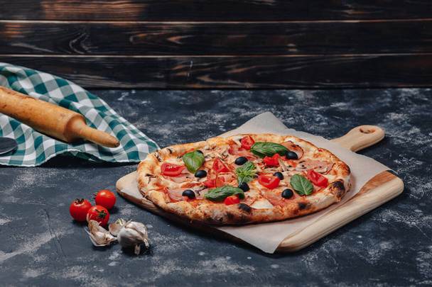 délicieuse pizza napolitaine sur un tableau noir aux tomates cerises, espace libre pour le texte
 - Photo, image