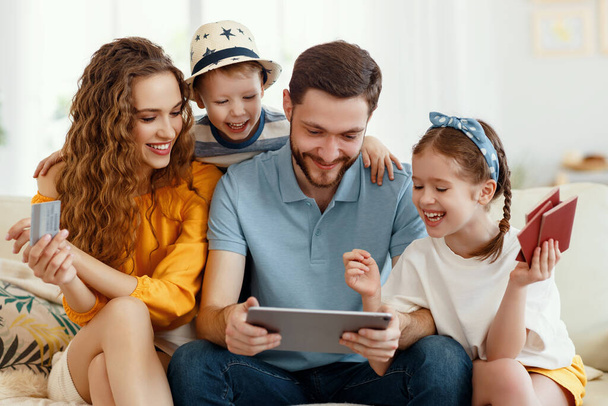 Smiling parents with kids gathering on sofa using tablet while picking tour online anticipating summer vacation all togethe - Foto, Imagem