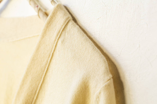 a sweater in white hanging on clothes hanger on white background.Close up. - Fotó, kép