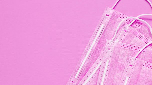 Предотвратить коронавирус. Медицинская маска, медицинская защитная маска на розовом фоне. Коронавирусная гигиена
 - Фото, изображение