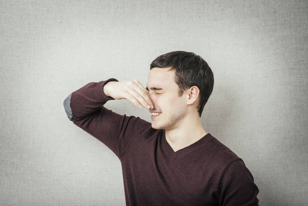 portrait of handsome man closing nose because something stinks - Фото, зображення