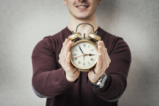 young man holding an alarm clock - Foto, afbeelding